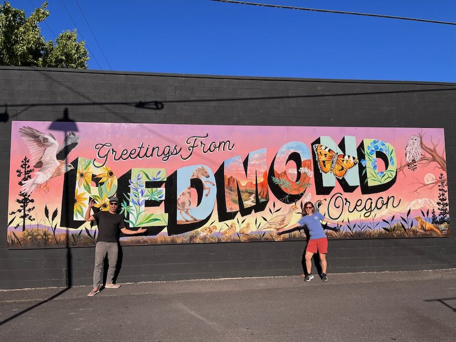 authors in front of Greetings From Redmond mural, Redmond Oregon downtown