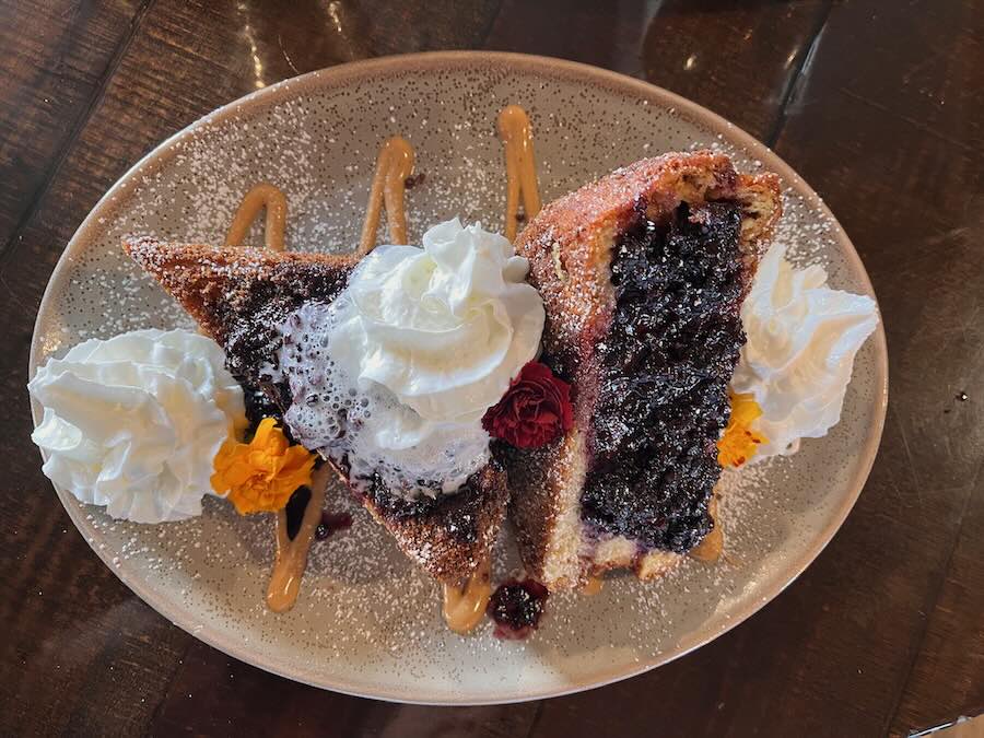 stacked french toast with peanut butter, berry compote, whipped cream